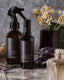 2 brown glass spray bottles on a marbled surface, arranged with fresh lavender and immortelle flowers